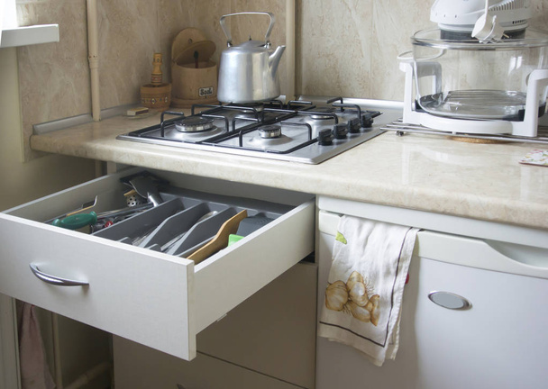 Газовая плита, чайник и ящик с кухонной утварью
. - Фото, изображение