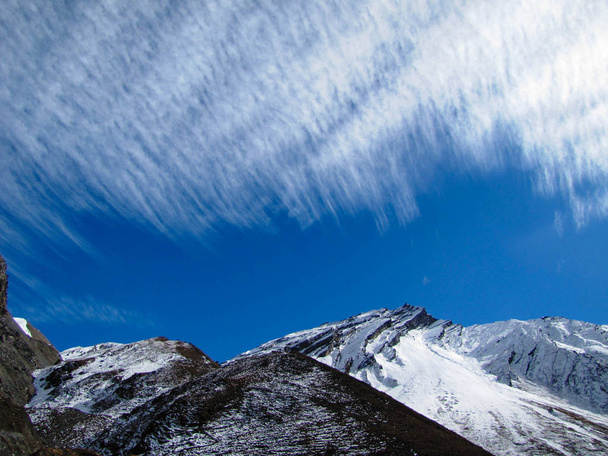 Imagen de tres capas de montañas, cielo despejado y nubes plumosas
  - Foto, Imagen