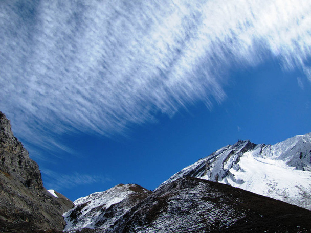 Three-layered image of mountains, clear sky and feathery clouds  - Foto, Bild