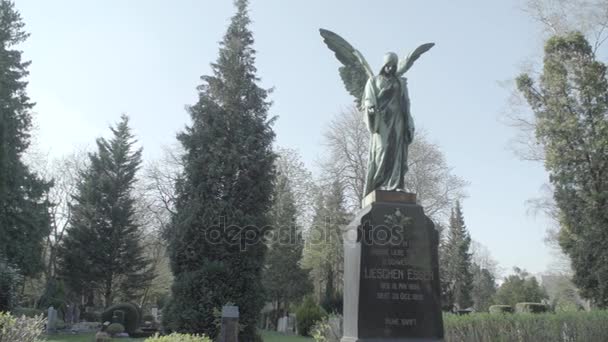 Oude grafsteen uit de 20e eeuw met een engel op een zonnige lentedag. Langzame pan van links naar rechts. 4k in Slog3. Grote schot. - Video