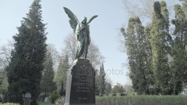 Oude grafsteen uit de 20e eeuw met een engel op een zonnige lentedag. Langzame pan van rechts naar links. 4k in Slog3. Grote schot. - Video