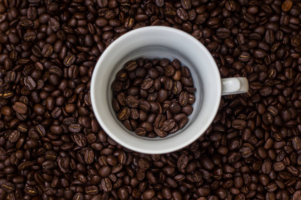 Koffiebonen in een kop, kopje koffie met bonen - Foto, afbeelding