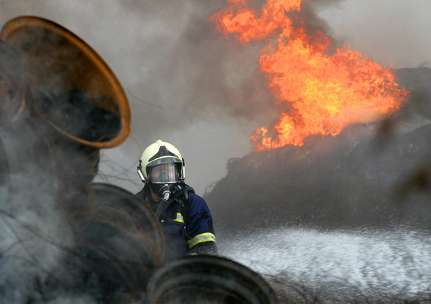 A fireman estinguishing fire of tyres - Photo, Image