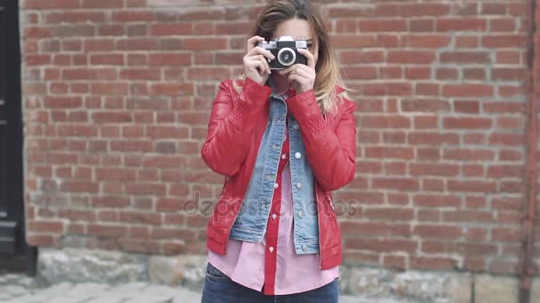 Jovem atraente tira fotos em uma câmera de filme
 - Filmagem, Vídeo