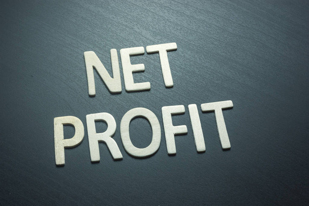 Net profit written with wooden letters on a green background - Photo, Image
