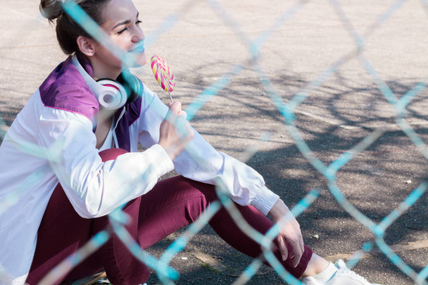 Urheilu tyttö syö karkkia ulkona
 - Valokuva, kuva