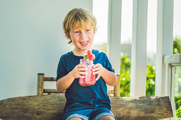 The boy is holding Healthy watermelon smoothie - Fotó, kép