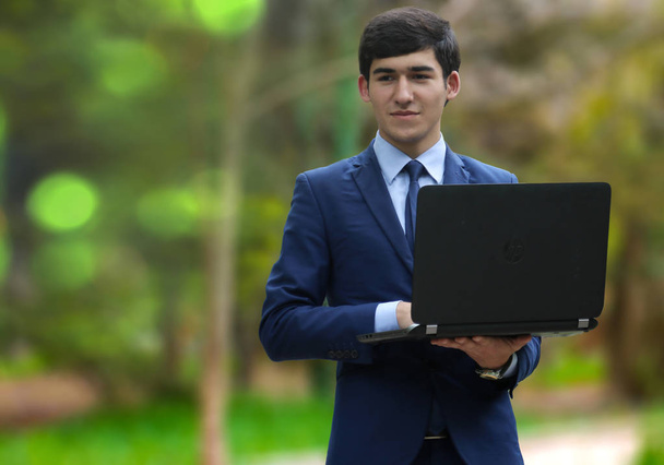 Joven emprendedor con ordenadores portátiles
 - Foto, Imagen