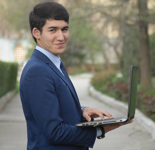    Uomo d'affari sorridente con laptop - Foto, immagini
