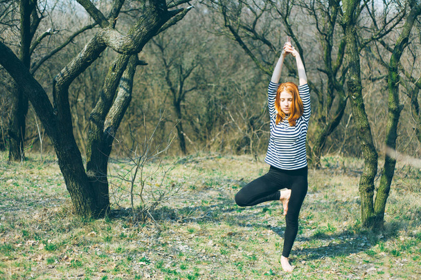 Egy gyönyörű kaukázusi lány csinál jóga és sport szabadban. Kora tavasszal, Kelet-Európában. - Fotó, kép