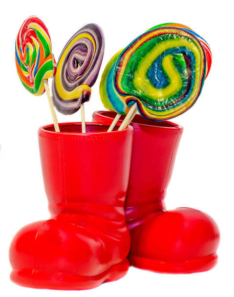 Красные сапоги Санта Клауса, туфли с цветными сладкими леденцами, конфеты
 - Фото, изображение
