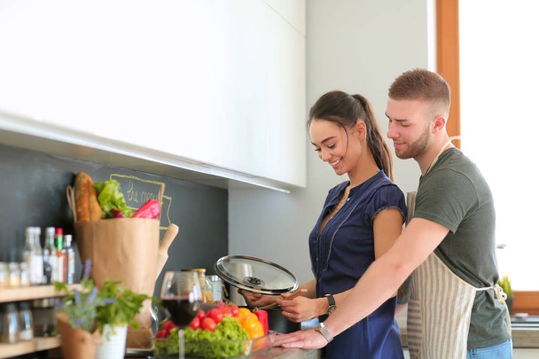 Couple cooking together in their kitchen at home - Valokuva, kuva