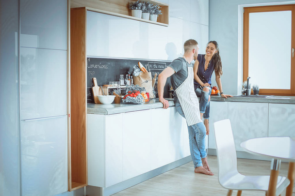 Beautiful young couple is having fun in kitchen at home - Foto, Imagem