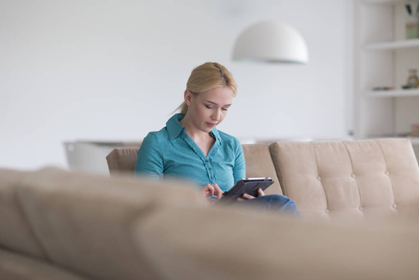 woman on sofa using tablet computer - Foto, immagini