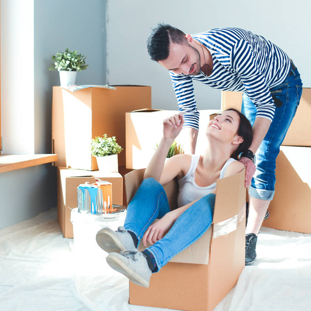 Щаслива молода пара розпаковує або упаковує коробки і переїжджає в новий будинок
 - Фото, зображення
