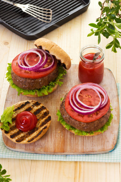 Grilled burgers with tomatoes on buns - Photo, Image