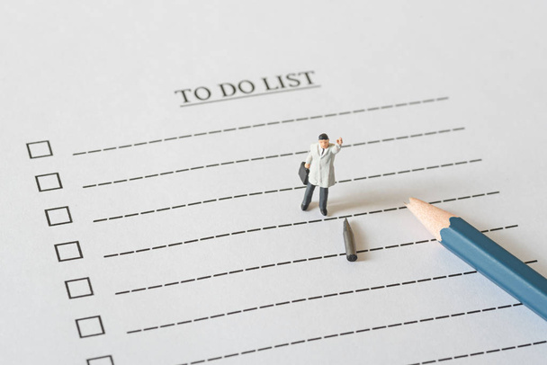 business miniature figures people on to do list with a broken pe - Foto, imagen