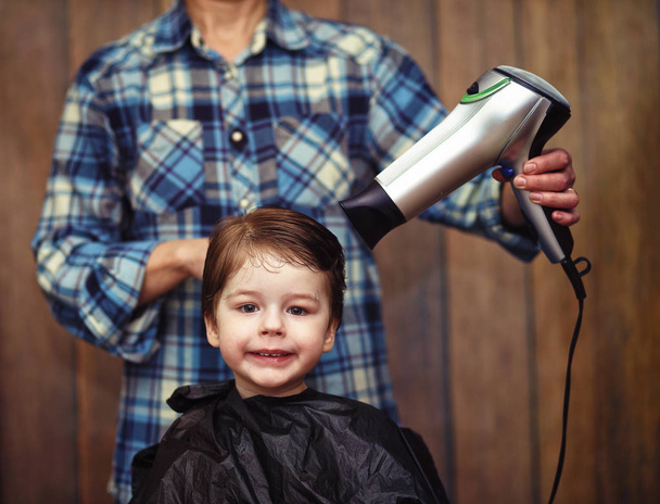 Um menino é aparado nos cabeleireiros
 - Foto, Imagem