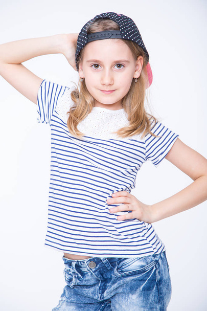 Little cheerful girl schoolgirl with blond hair and cap hat - Fotó, kép