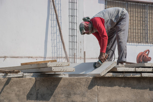 Bouwer werknemer met grinder machine snijden concreate vloer op bouwplaats - Foto, afbeelding