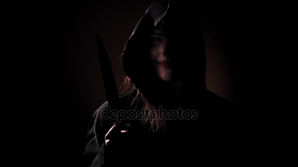 grimmiges Mädchen in einem rituellen Kleiderschrank mit einem Messer in einem dunklen - Filmmaterial, Video