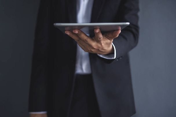 Modern Businessman holding a digital tablet, front view - 写真・画像