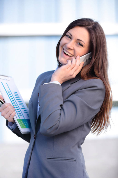 Business woman talking on smart phone . Business people office worker talking on smartphone smiling happy. Young caucasian female professional outside. - Photo, image