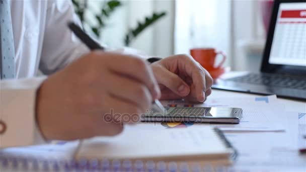 Бізнесмен рука з фінансовими графіками на мобільному телефоні малювання даних в блокноті
 - Кадри, відео
