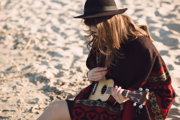 Happy young woman playing on ukulele at beach - Valokuva, kuva