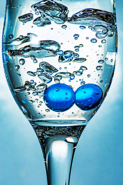 Kék üveggolyó, egy pohár vízben - Fotó, kép