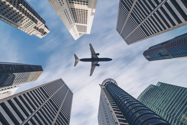 Самолет пролетает над городскими деловыми зданиями, высотный небоскреб
 - Фото, изображение