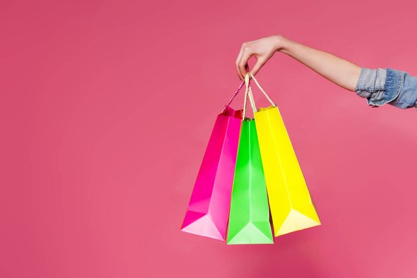 Female hand holding colorful shopping bags - Foto, imagen