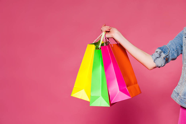 Female hand holding colorful shopping bags - Fotó, kép