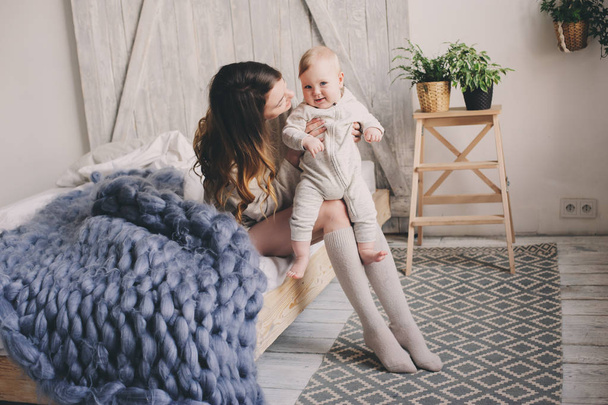 happy mother and baby playing at home in bedroom. Cozy family lifestyle in modern scandinavian interior.  - Fotografie, Obrázek
