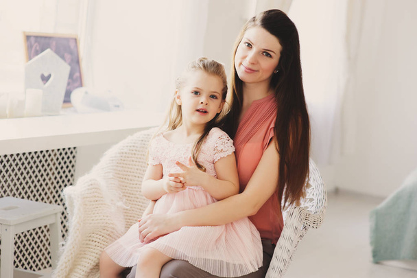 happy family sitting on chair at home. Casual lifestyle capture of mother and toddler daughter - Photo, Image