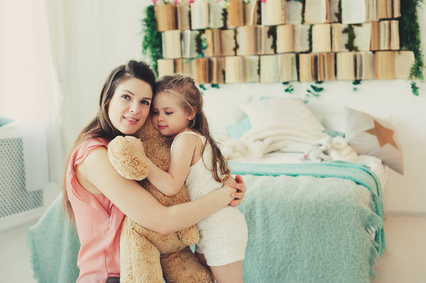 Szczęśliwa rodzina, w domu. Matka i toddler córka relaksu i zabawy w łóżku przytulne weekend rano - Zdjęcie, obraz