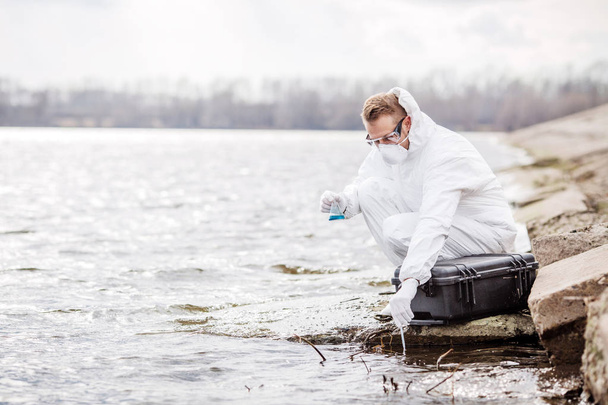 Scientists or biologists wearing protective uniforms working together on water analysis.  - Foto, imagen