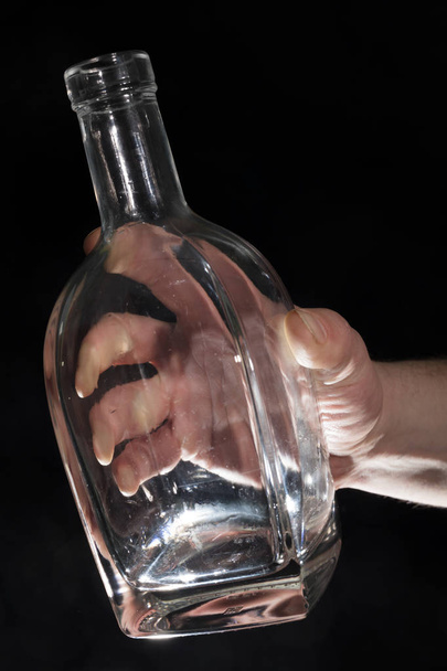 Mans hand holding empty bottle of alcohol - Photo, image