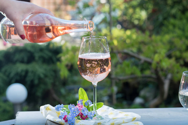 Serveur versant un verre de vin de rose froid, terrasse extérieure, ensoleillé
  - Photo, image