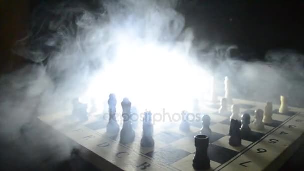 Schaken bordspel concept van bedrijfsideeën en concurrentie en strategie ideeën concep. Chess cijfers op een donkere achtergrond met rook en mist. Selectieve aandacht - Video
