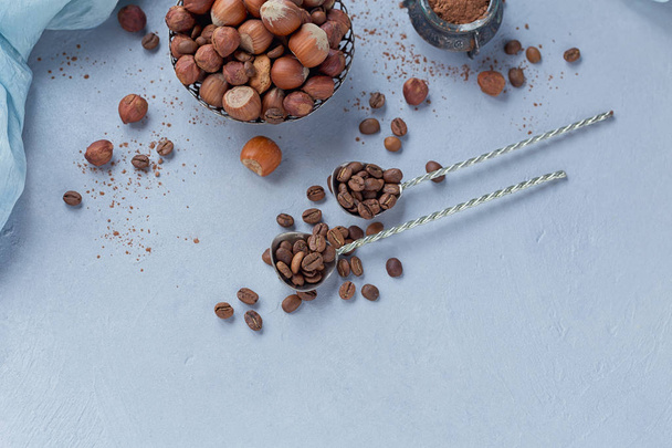 Hazelnut, coffee beans and cocoa powder in light blue background - Photo, Image