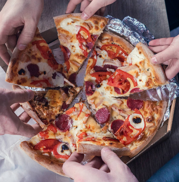 Visão superior de mãos tomando pizza
 - Foto, Imagem