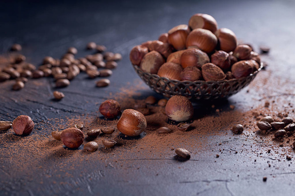 Фундук, кавові зерна та порошок какао на темному фоні
. - Фото, зображення
