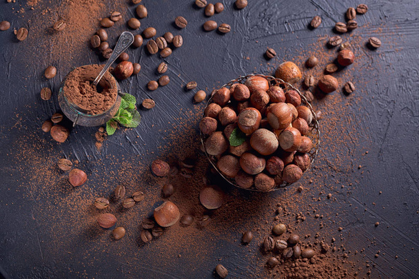 Hazelnut, coffee beans and cocoa powder in dark background. - Zdjęcie, obraz