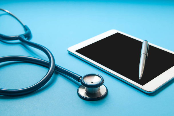 聴診器、青い色の背景上のタブレット pc。医療テクノロジーのセキュリティアスペクト - 写真・画像