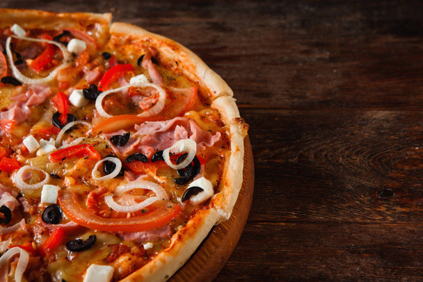 Pizza in Scheiben schneiden, aus nächster Nähe. italienisches Junk Food. - Foto, Bild