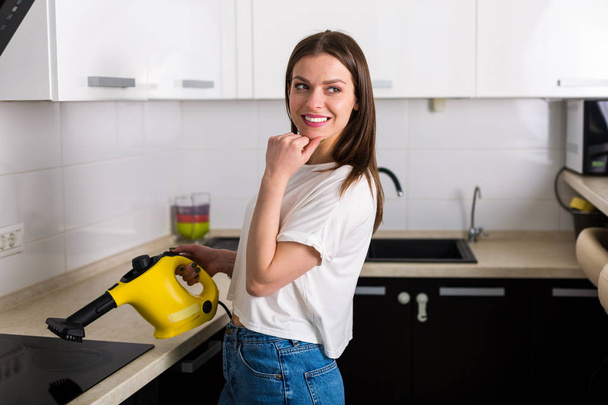 Mujer cocina de limpieza con limpiador de vapor
 - Foto, imagen