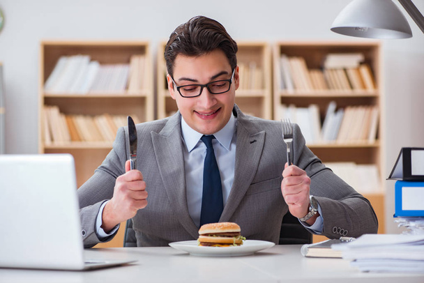Hungriger, lustiger Geschäftsmann isst Junkfood-Sandwich - Foto, Bild