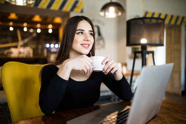 Mujer alegre usando el ordenador portátil y beber café
 - Foto, Imagen