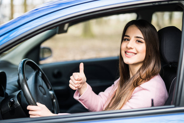 beautiful businesswoman giving thumb up inside her car - Photo, Image